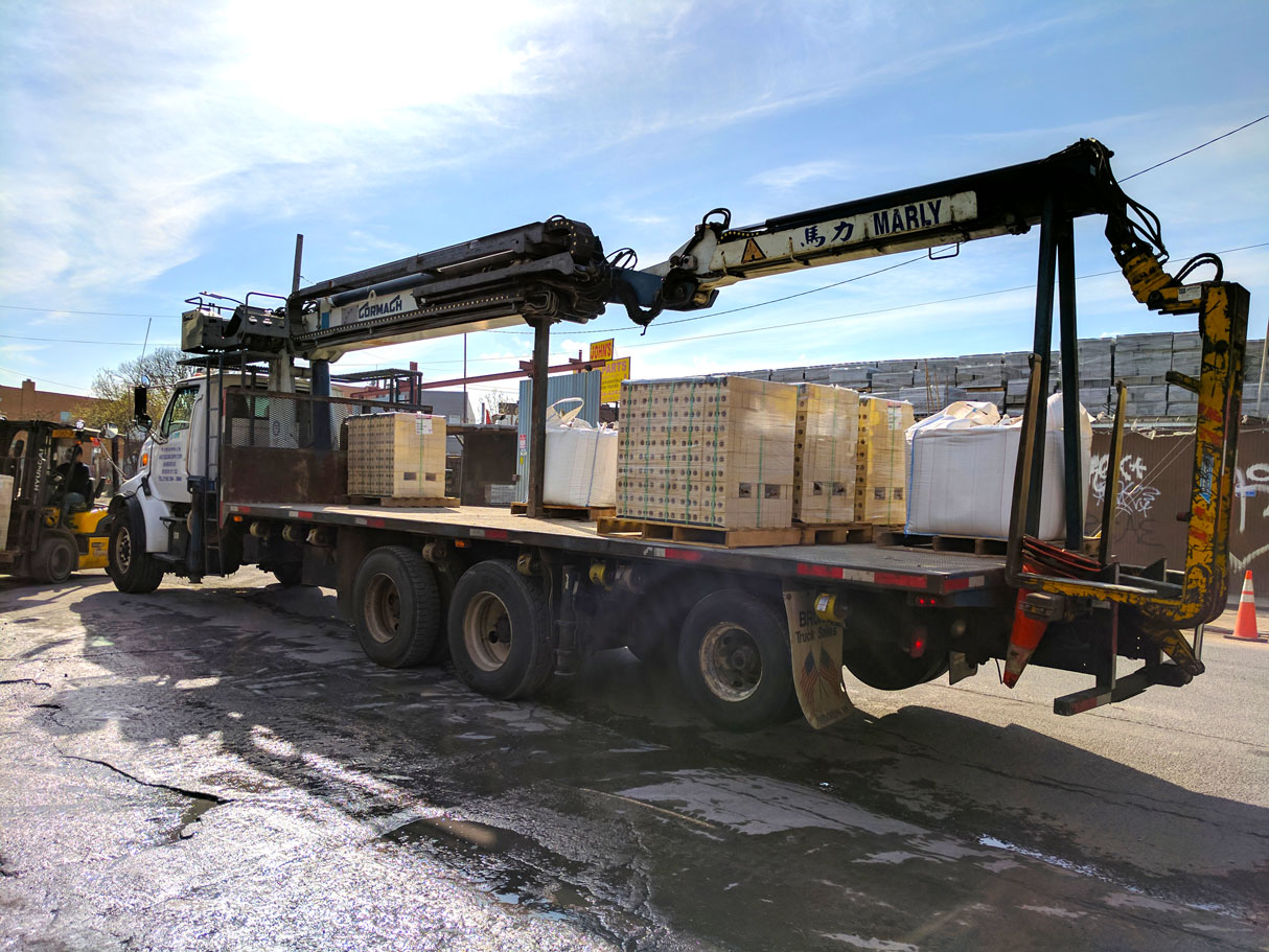 Boom trailer carrying banded brick cubes