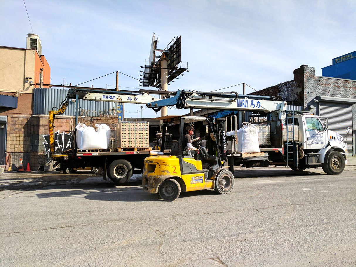 Two forklifts working a delivery load
