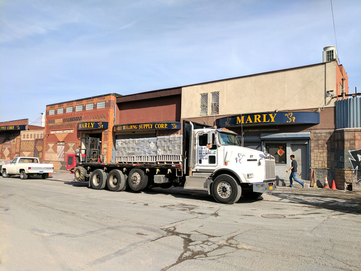 Flatbed alongside the Marly storefront